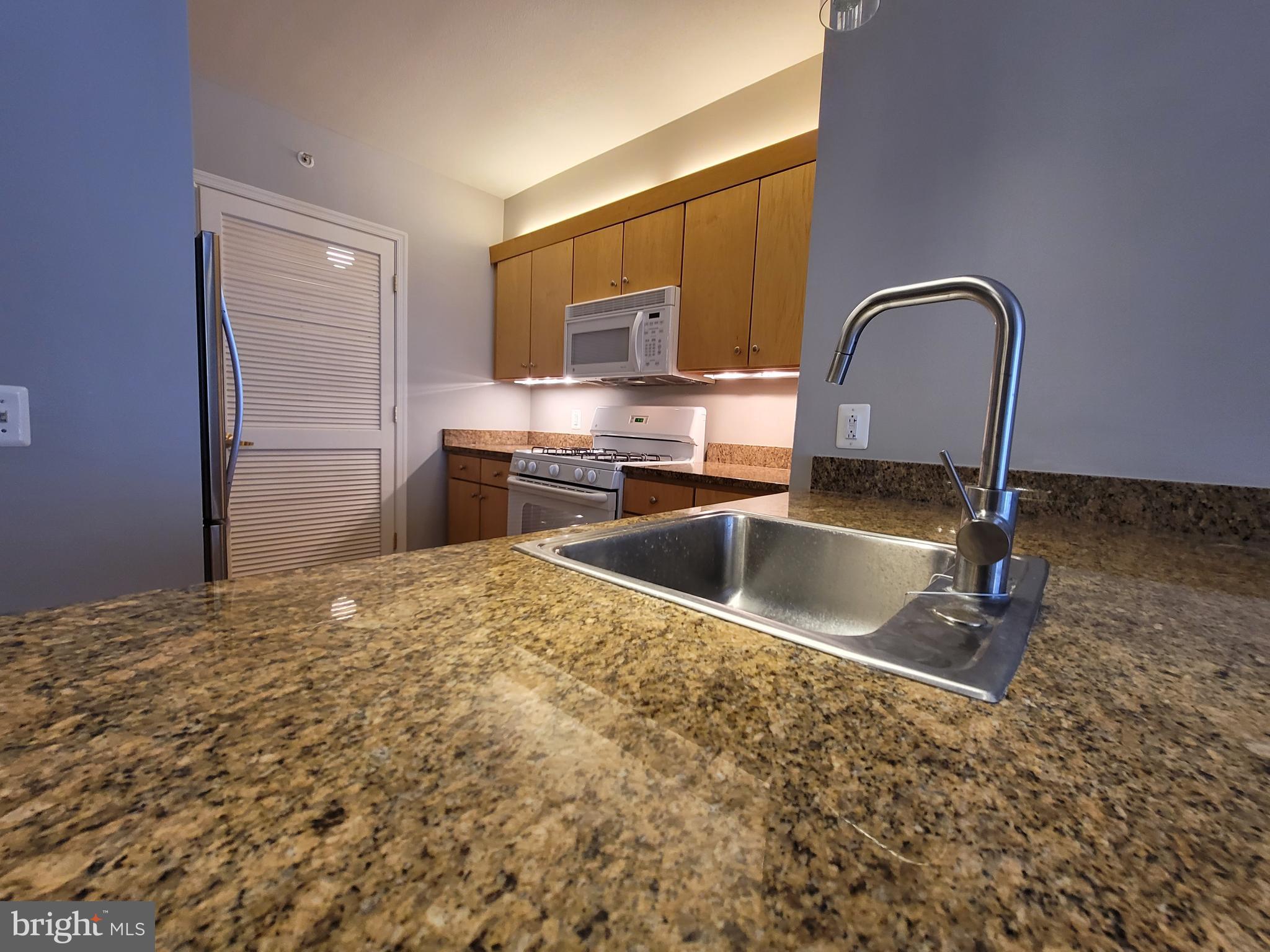 631 D Street Northwest, Unit 1132 Washington, DC 20004 - Photo 13 of 58 a kitchen with stainless steel appliances granite countertop a sink a stove and a refrigerator