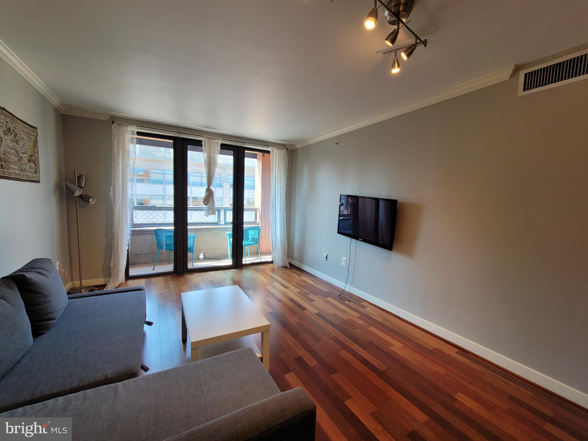 631 D Street Northwest, Unit 1132 Washington, DC 20004 - Photo 15 of 58 a living room with furniture and a flat screen tv
