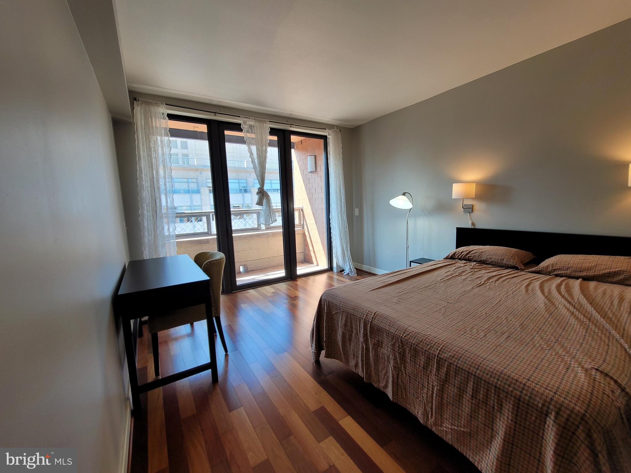 631 D Street Northwest, Unit 1132 Washington, DC 20004 - Photo 20 of 58 a bedroom with a bed a table and wooden floor