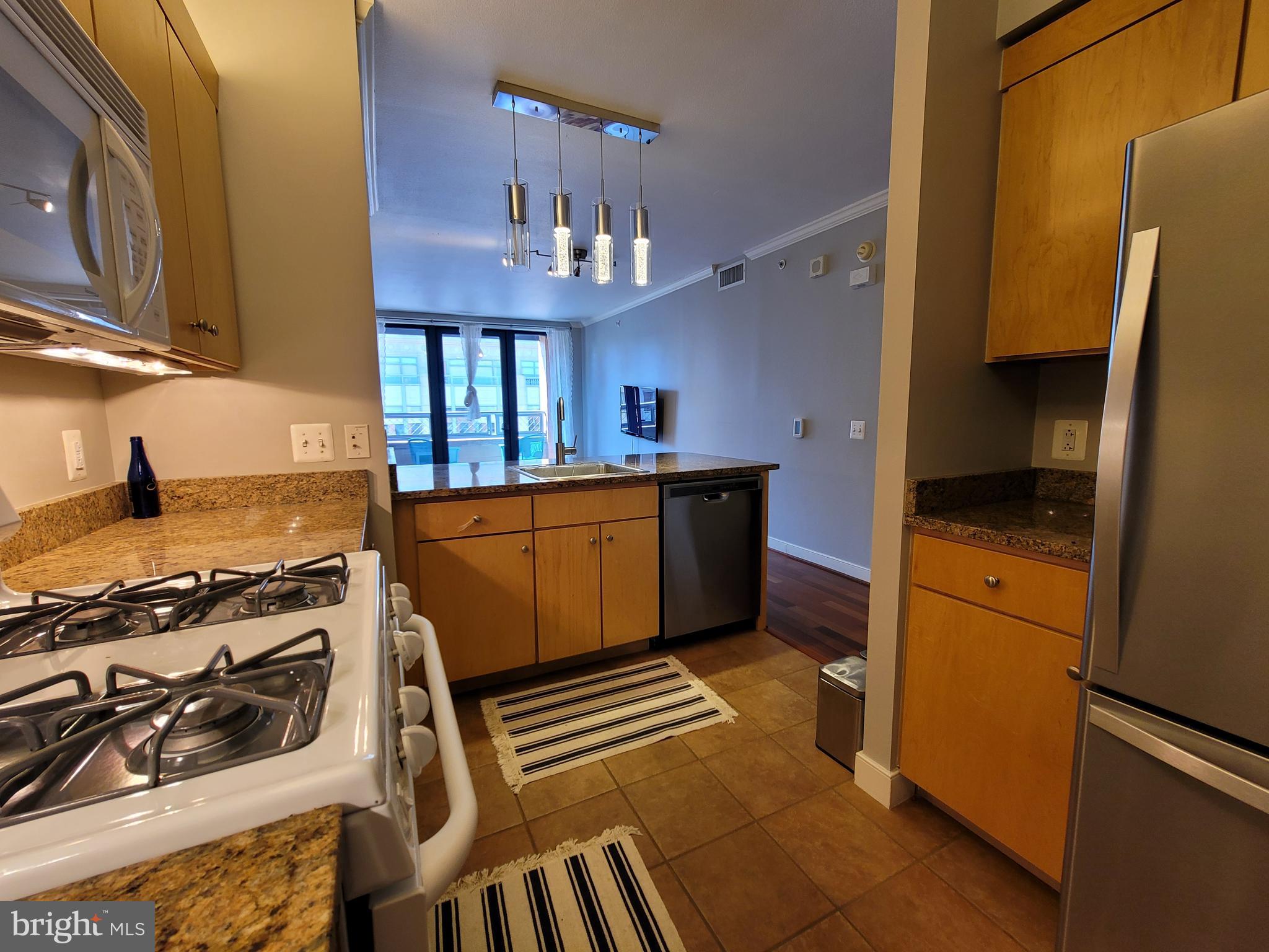 631 D Street Northwest, Unit 1132 Washington, DC 20004 - Photo 9 of 58 a kitchen with stainless steel appliances granite countertop a stove a refrigerator and a cabinets