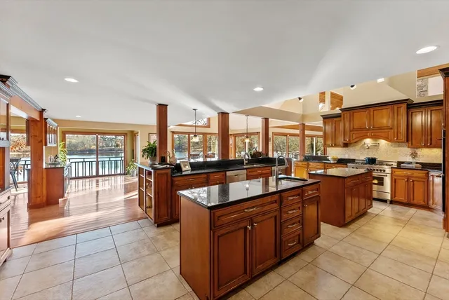 a large kitchen with kitchen island granite countertop a large counter top and stainless steel appliances