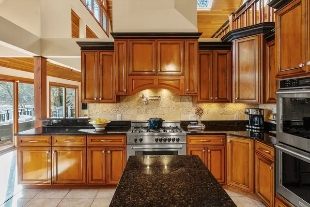 a kitchen with stainless steel appliances granite countertop a stove a sink and a microwave