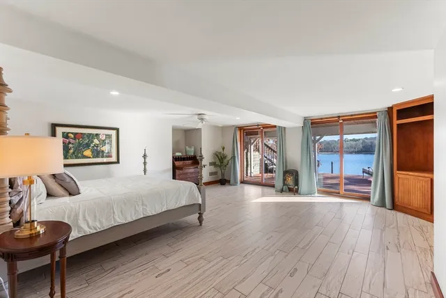 a spacious bedroom with a large bed and a wooden floor