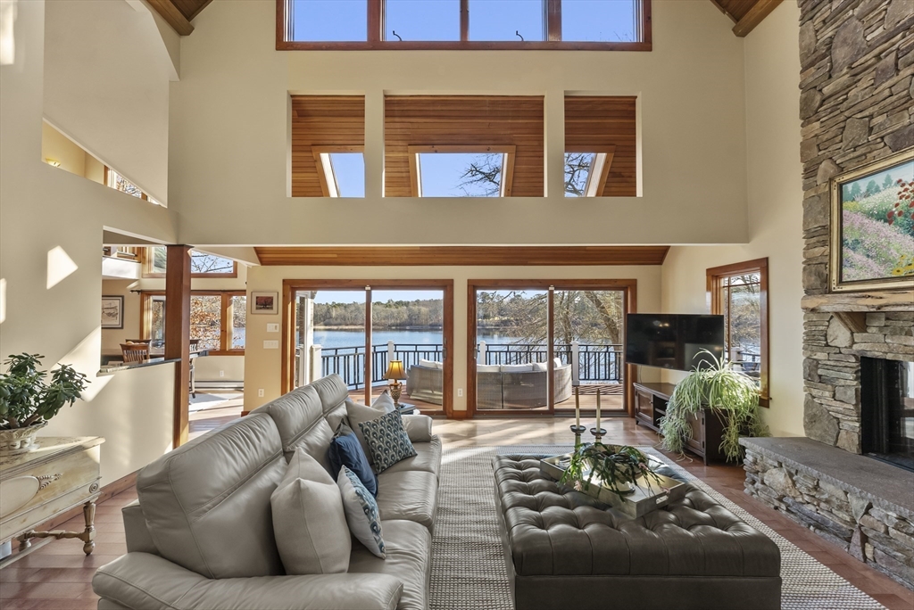 82 Lake Road Plymouth, MA 02360 - Photo 10 of 42 a living room with furniture fireplace and a floor to ceiling window