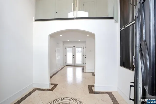 a view of a hallway with wooden floor and a bathroom