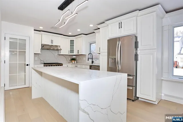a kitchen with stainless steel appliances a refrigerator sink and stove