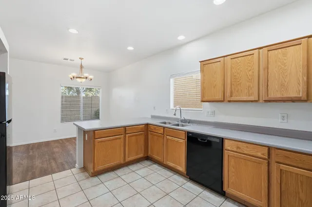 a kitchen with granite countertop white cabinets stainless steel appliances and a chandelier