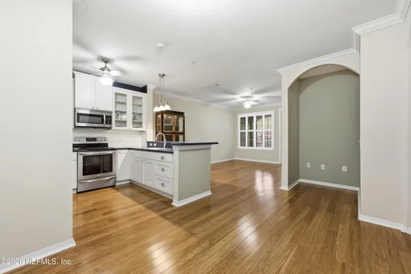an empty room with wooden floor and windows