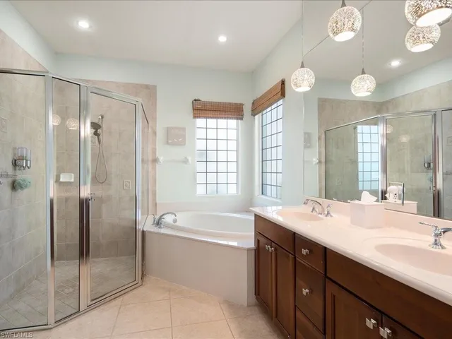 a bathroom with a tub sink shower and a mirror