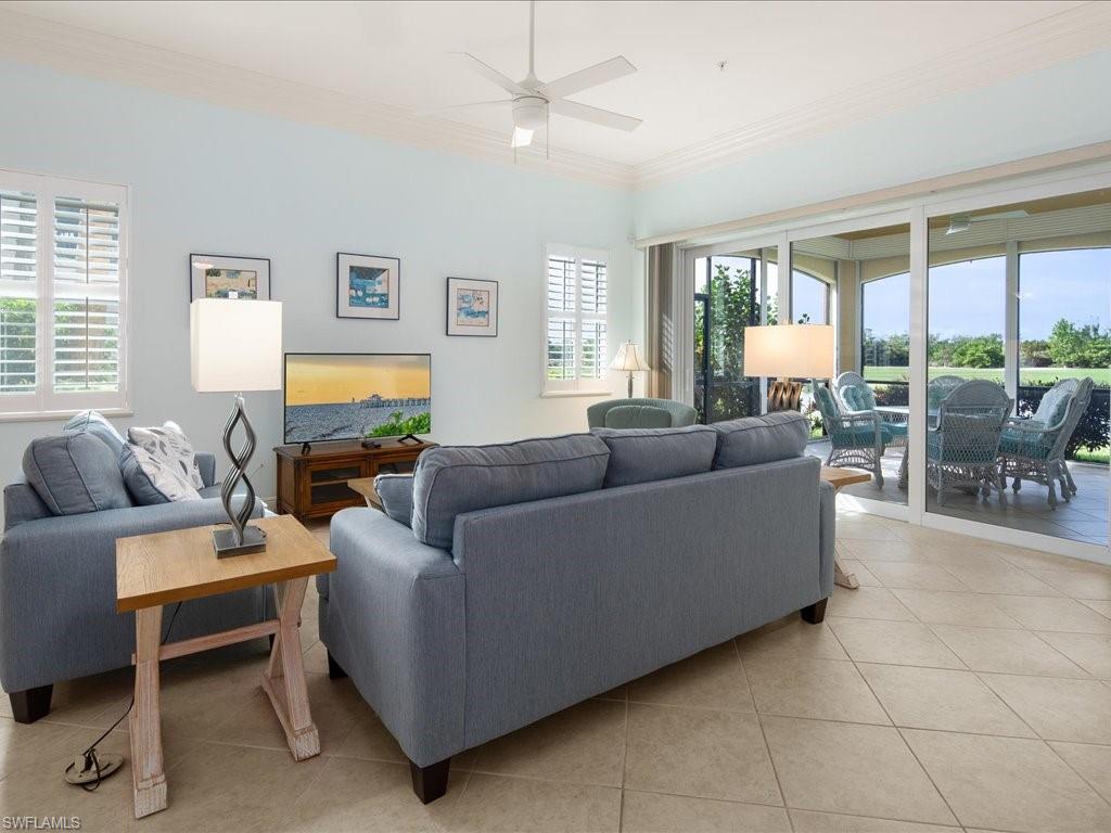 1498 Borghese Lane, Unit 101 Naples, FL 34114 - Photo 9 of 34 a living room with furniture and a large window