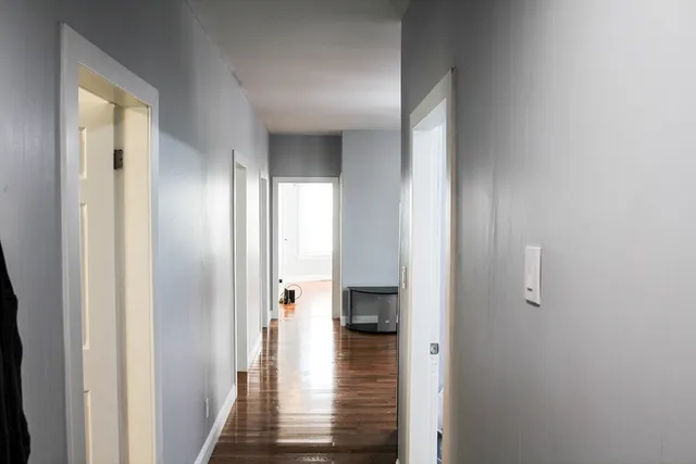 a view of a hallway with dining room and wooden floor