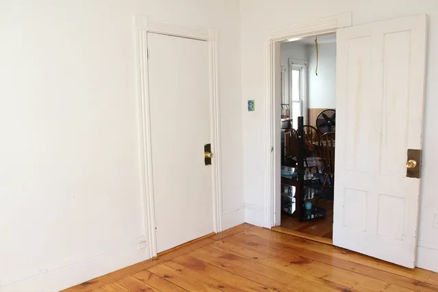 a view of a bedroom with wooden floor and closet