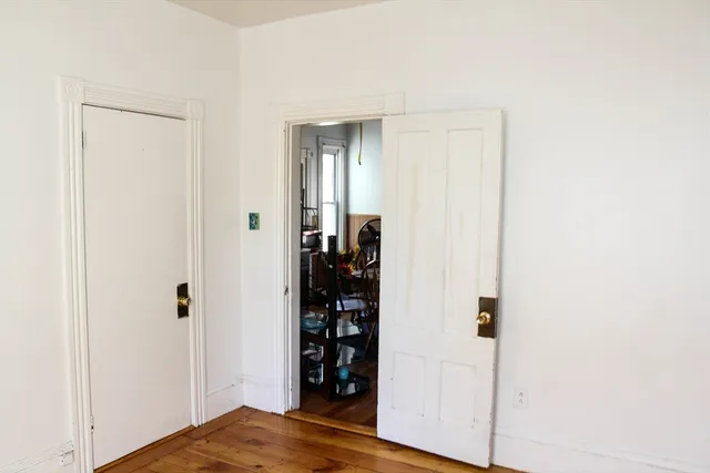 a view of a bedroom with wooden floor and closet