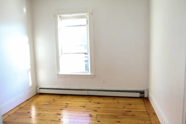 a view of a room with wooden floor and a window