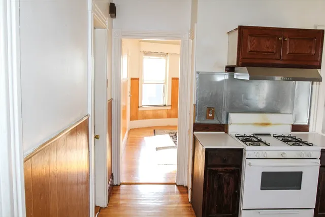 a kitchen with granite countertop cabinets stainless steel appliances and a wooden floor