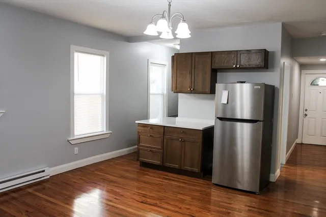 a kitchen with stainless steel appliances granite countertop a refrigerator microwave and wooden floor