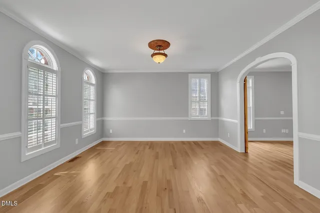 a bedroom with a large bed a chandelier and windows