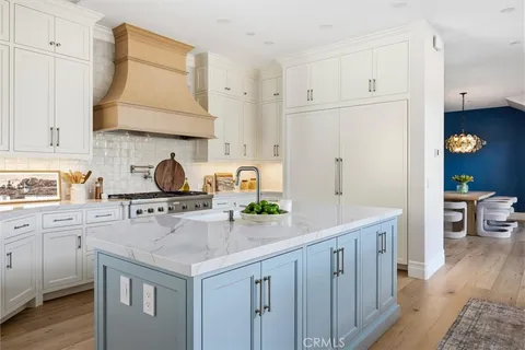 a kitchen with white cabinets and sink
