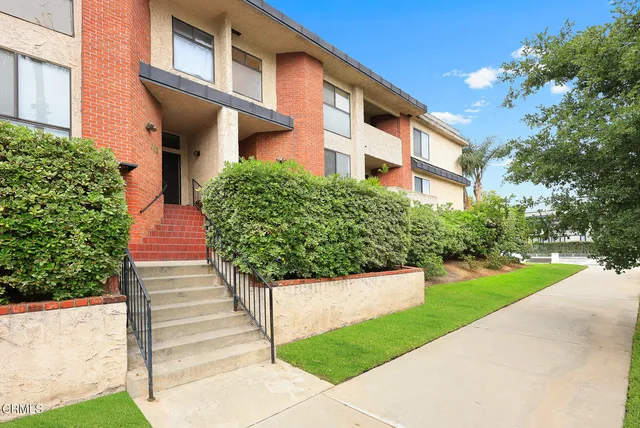 a front view of a multi story building with yard