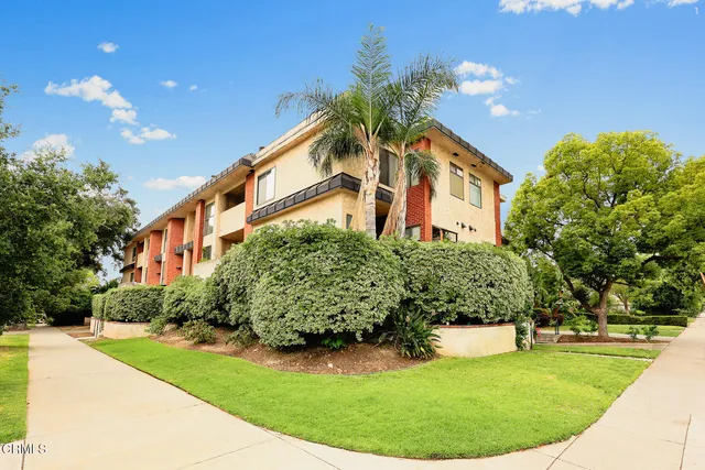 a front view of a house with a garden and plants