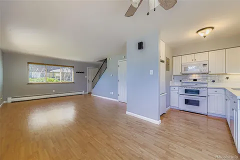 a kitchen with kitchen island wooden floors appliances and cabinets