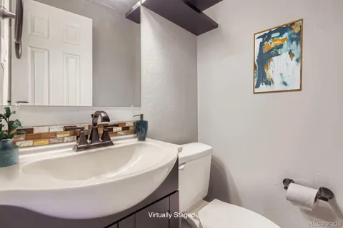 a bathroom with a sink a toilet and mirror