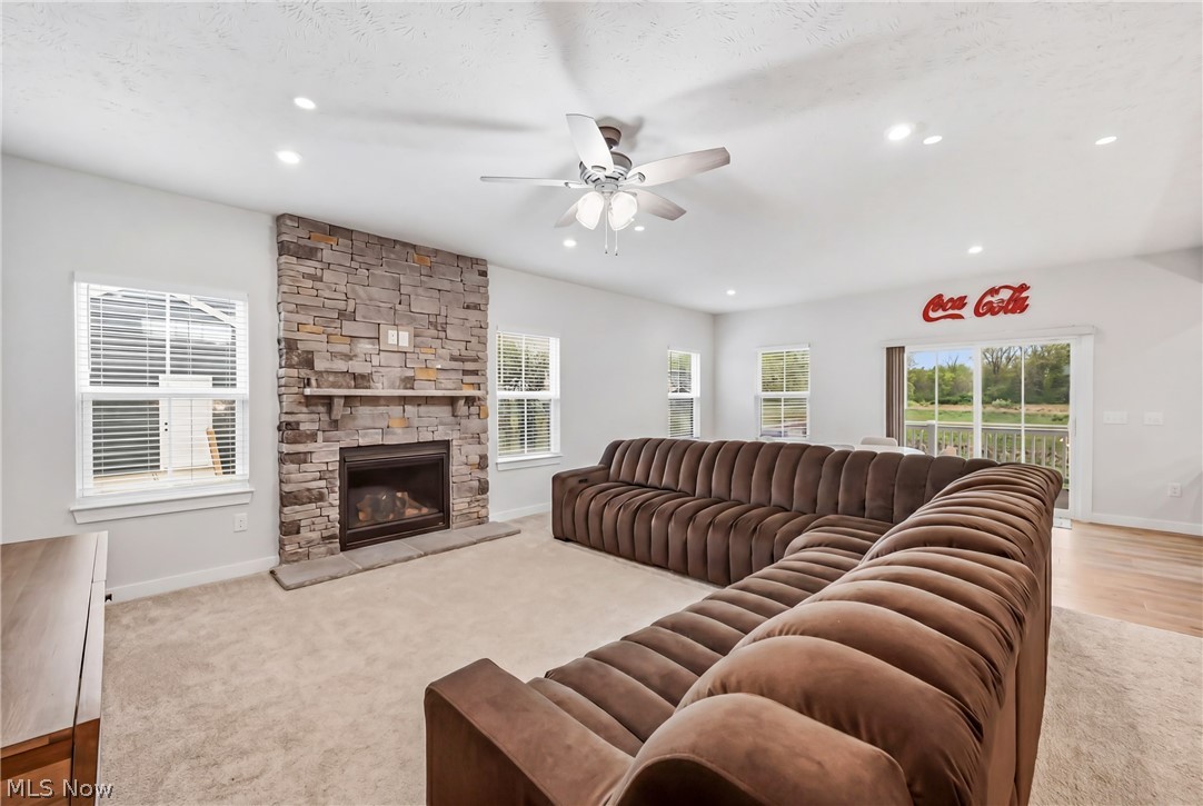 5358 Walnut Rdg Lane Sheffield Lake, OH 44054 - Photo 15 of 50 Living room featuring a stone-clad fireplace with a hearth, multiple windows with blinds, recessed lighting, and a ceiling fan