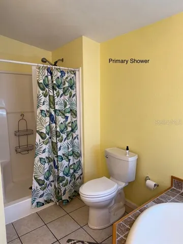 a bathroom with a toilet and shower curtain