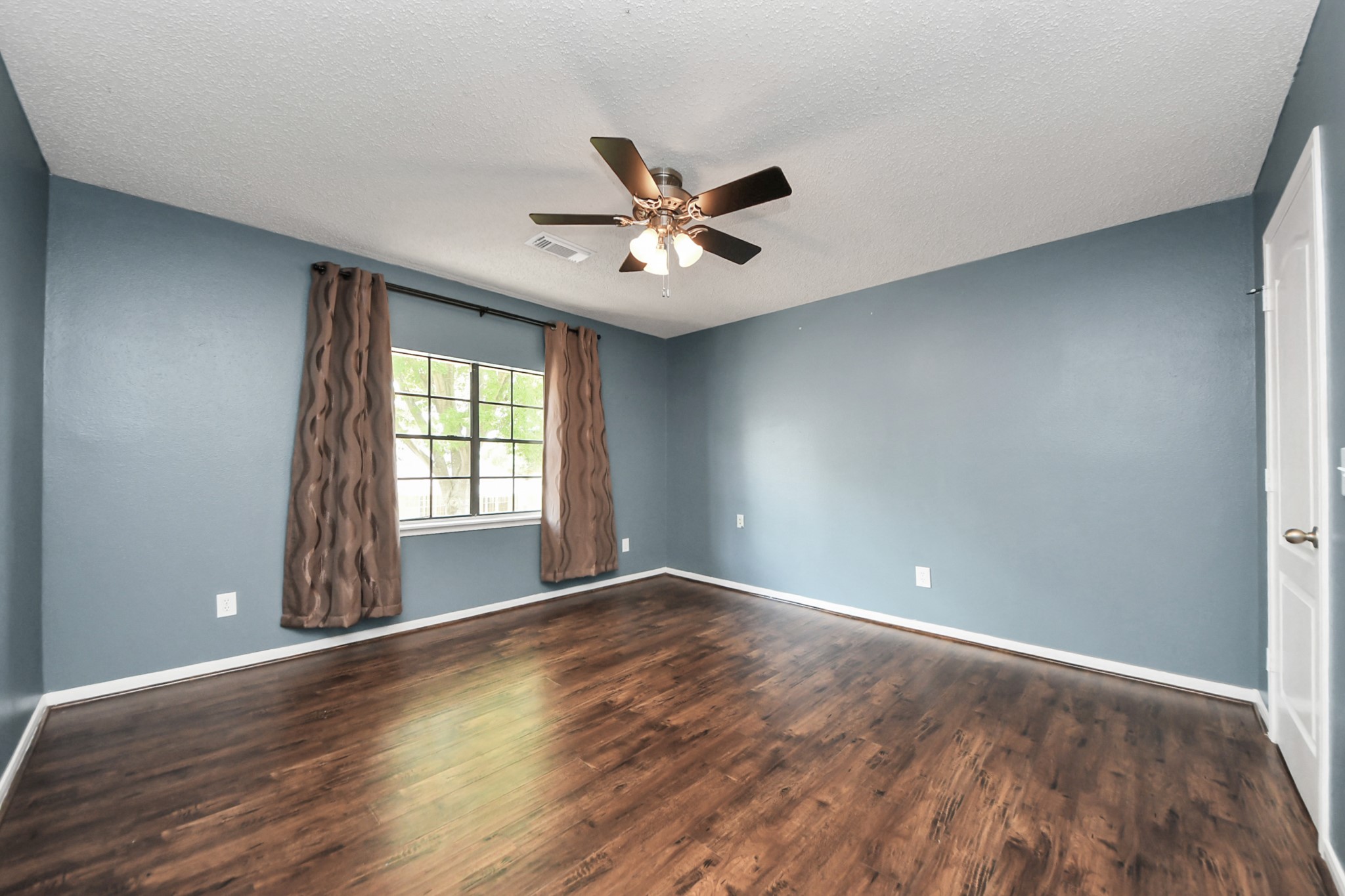 3107 Dulaney Road Houston, TX 77084 - Photo 38 of 50 a view of an empty room with window and wooden floor