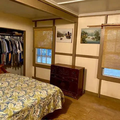 a bed sitting in a bedroom next to a window