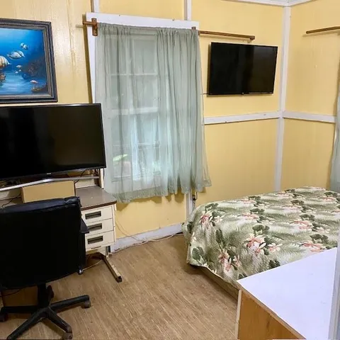a bedroom with a bed and a flat screen tv