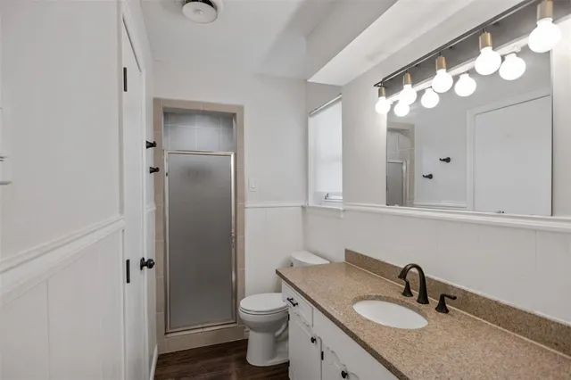 a bathroom with a sink vanity granite toilet and a mirror