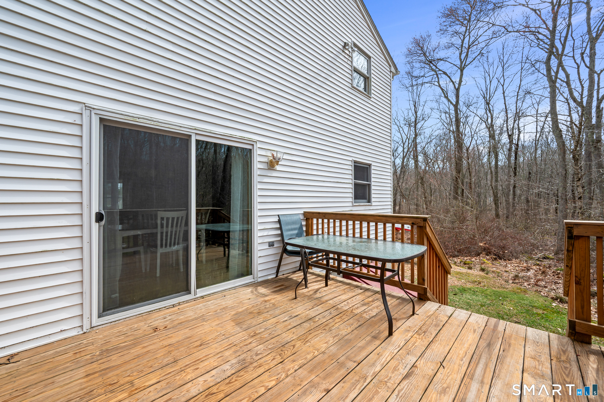 146 Lakeside Drive Andover, CT 06232 - Photo 25 of 35 a view of a wooden deck with a bench and floor to ceiling window