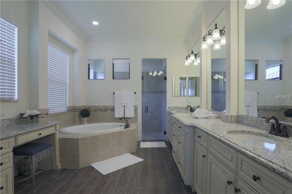 5528 Arnie Loop Lakewood Ranch, FL 34211 - Photo 16 of 59 a bathroom with a sink double vanity granite tub shower and a mirror