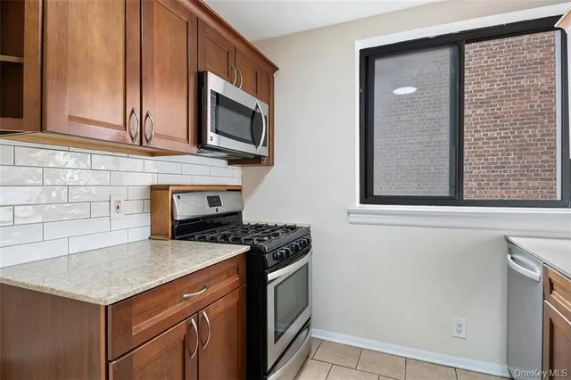 a kitchen with stainless steel appliances granite countertop a stove a microwave and a sink