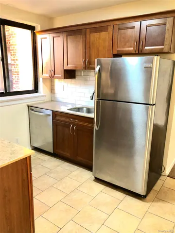 a kitchen with granite countertop a refrigerator and a sink