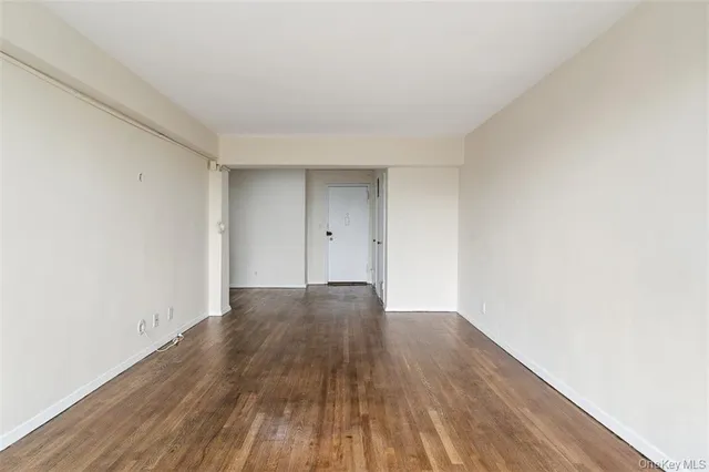 a view of an empty room and wooden floor