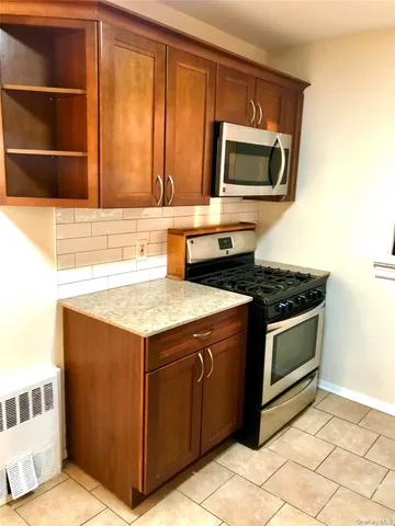 a kitchen with granite countertop a stove and a microwave