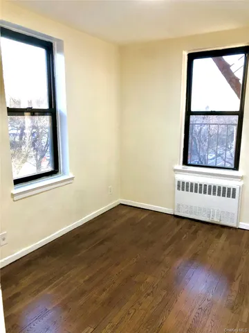 a view of a room with wooden floor and a window