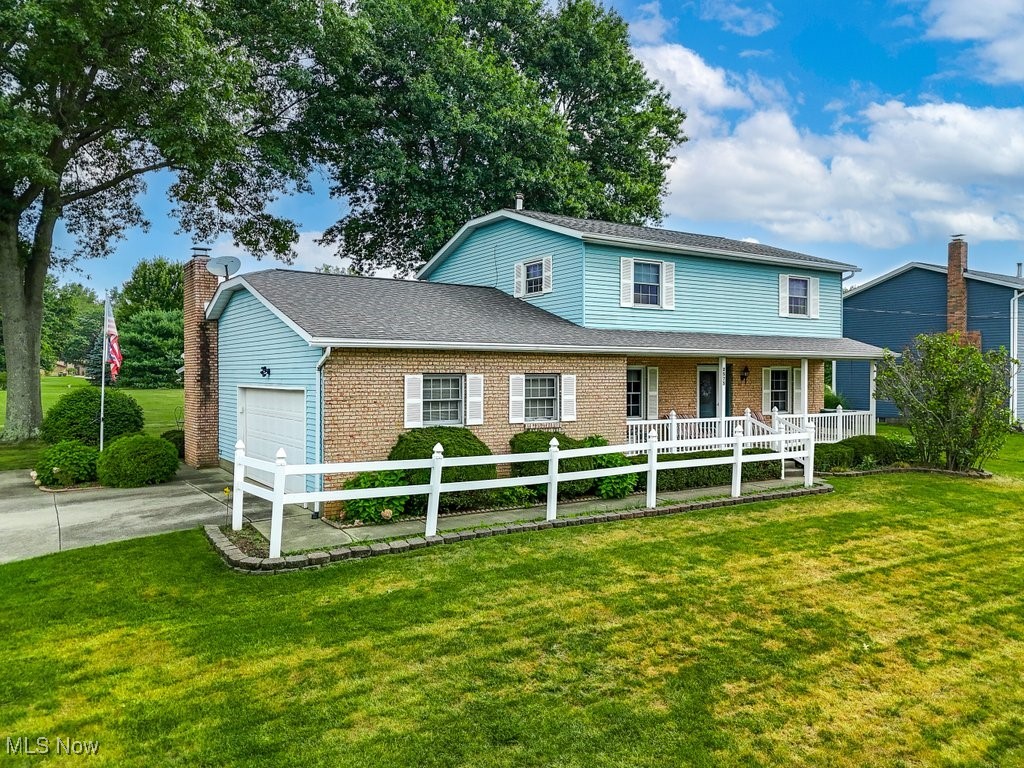 2573 Killian Road Uniontown, OH 44685 - Photo 28 of 40 View of front of property with a porch, a garage, and a front lawn