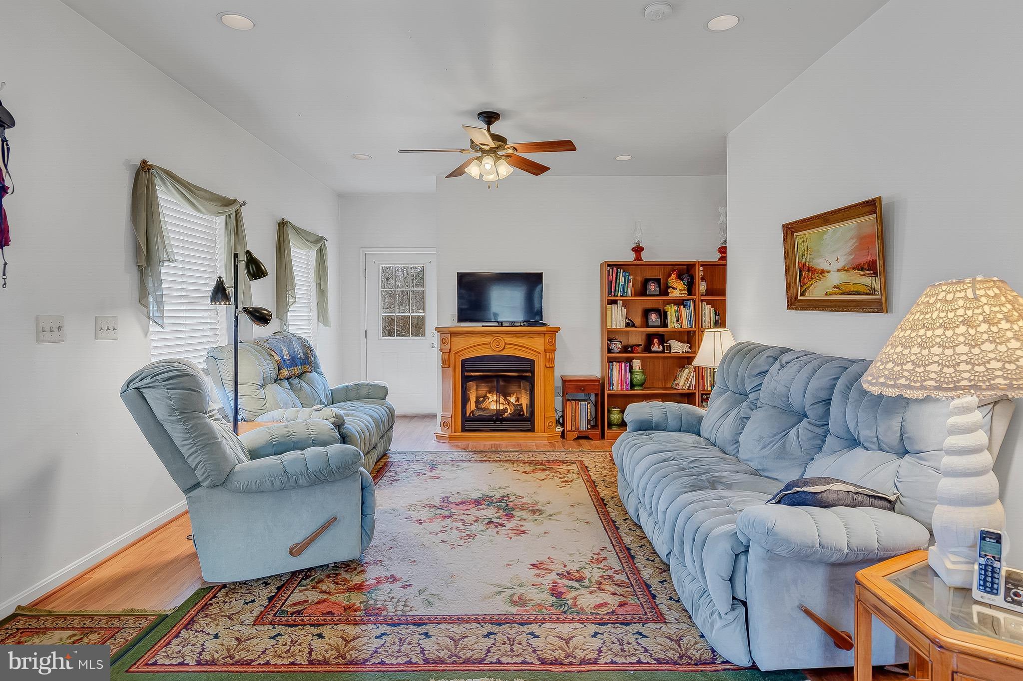 10120 Mackall Road St. Leonard, MD 20685 - Photo 19 of 29 a living room with furniture a fireplace and a flat screen tv