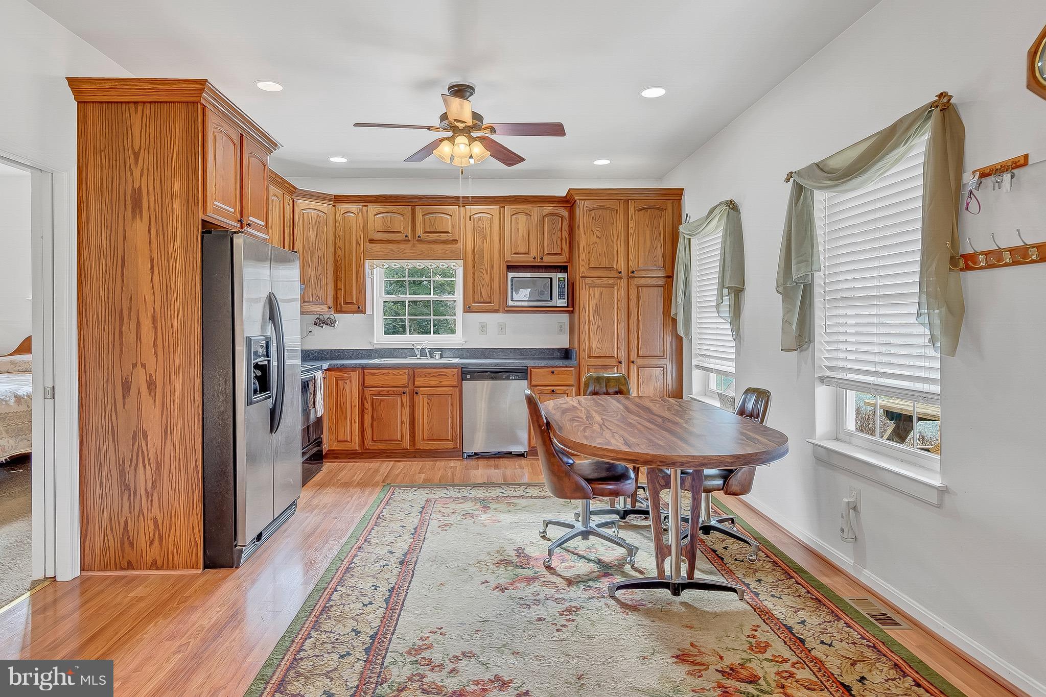 10120 Mackall Road St. Leonard, MD 20685 - Photo 20 of 29 a kitchen with stainless steel appliances kitchen island granite countertop a refrigerator a sink and a stove