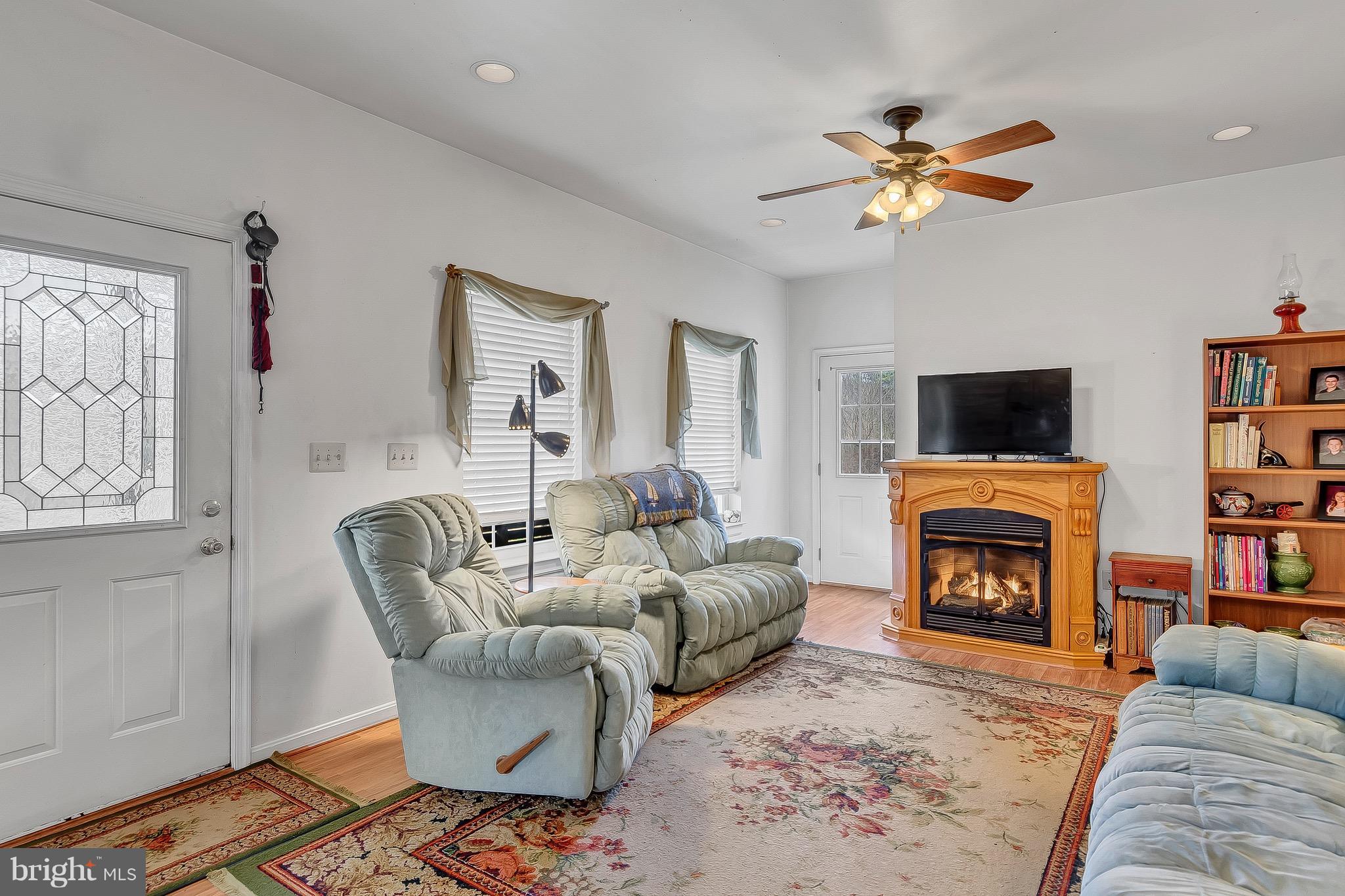 10120 Mackall Road St. Leonard, MD 20685 - Photo 21 of 29 a living room with furniture a fireplace and a flat screen tv