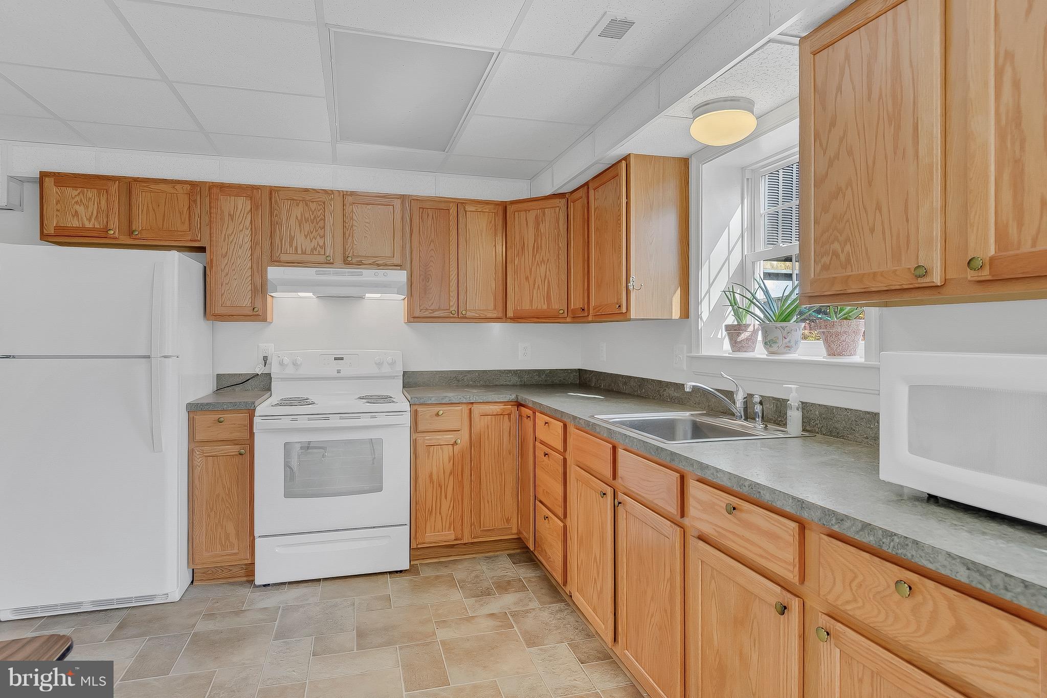 10120 Mackall Road St. Leonard, MD 20685 - Photo 25 of 29 a kitchen with sink cabinets and window