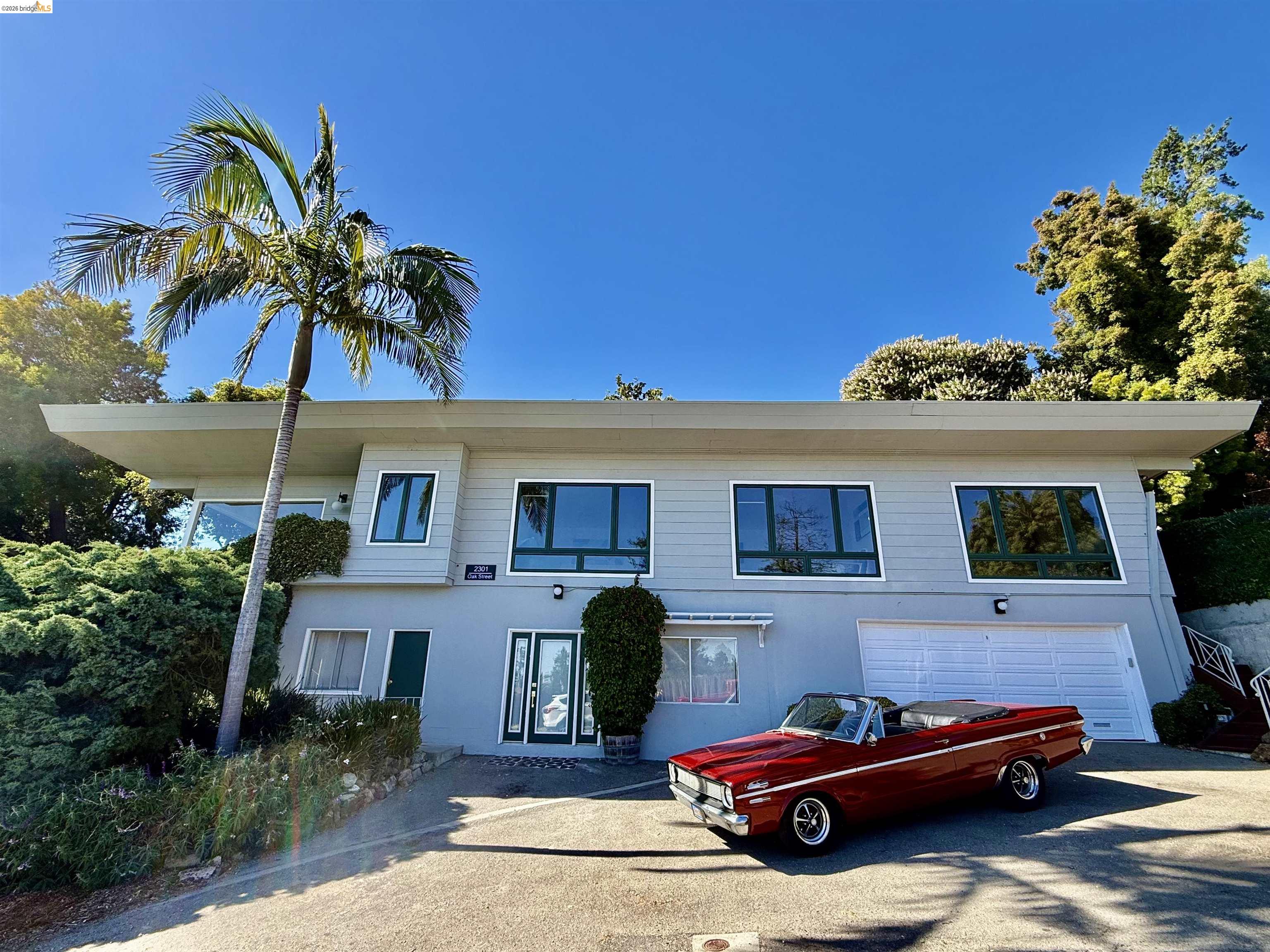 2301 Oak Street Berkeley, CA 94708 - Photo 56 of 61 Contemporary architectural design featuring a prominent flat roofline, an integrated garage with a white door, and multiple large windows with contrasting dark frames