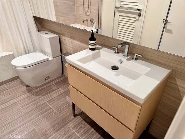 a bathroom with a sink toilet and mirror