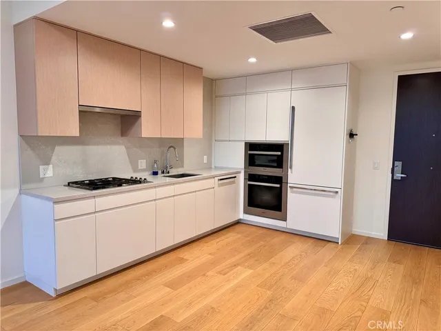 a kitchen with stainless steel appliances white cabinets and a refrigerator