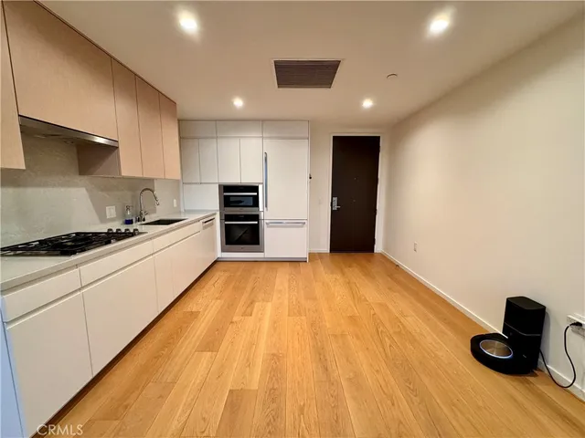 a kitchen with a refrigerator and a stove top oven