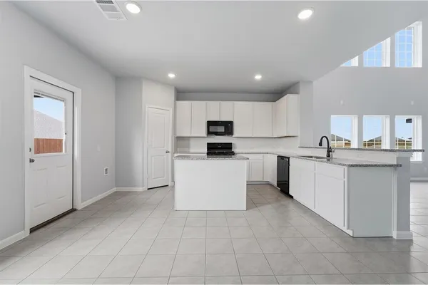 a kitchen with stainless steel appliances granite countertop a refrigerator and a stove