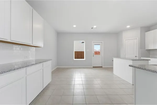 a kitchen with stainless steel appliances granite countertop a sink and white cabinets